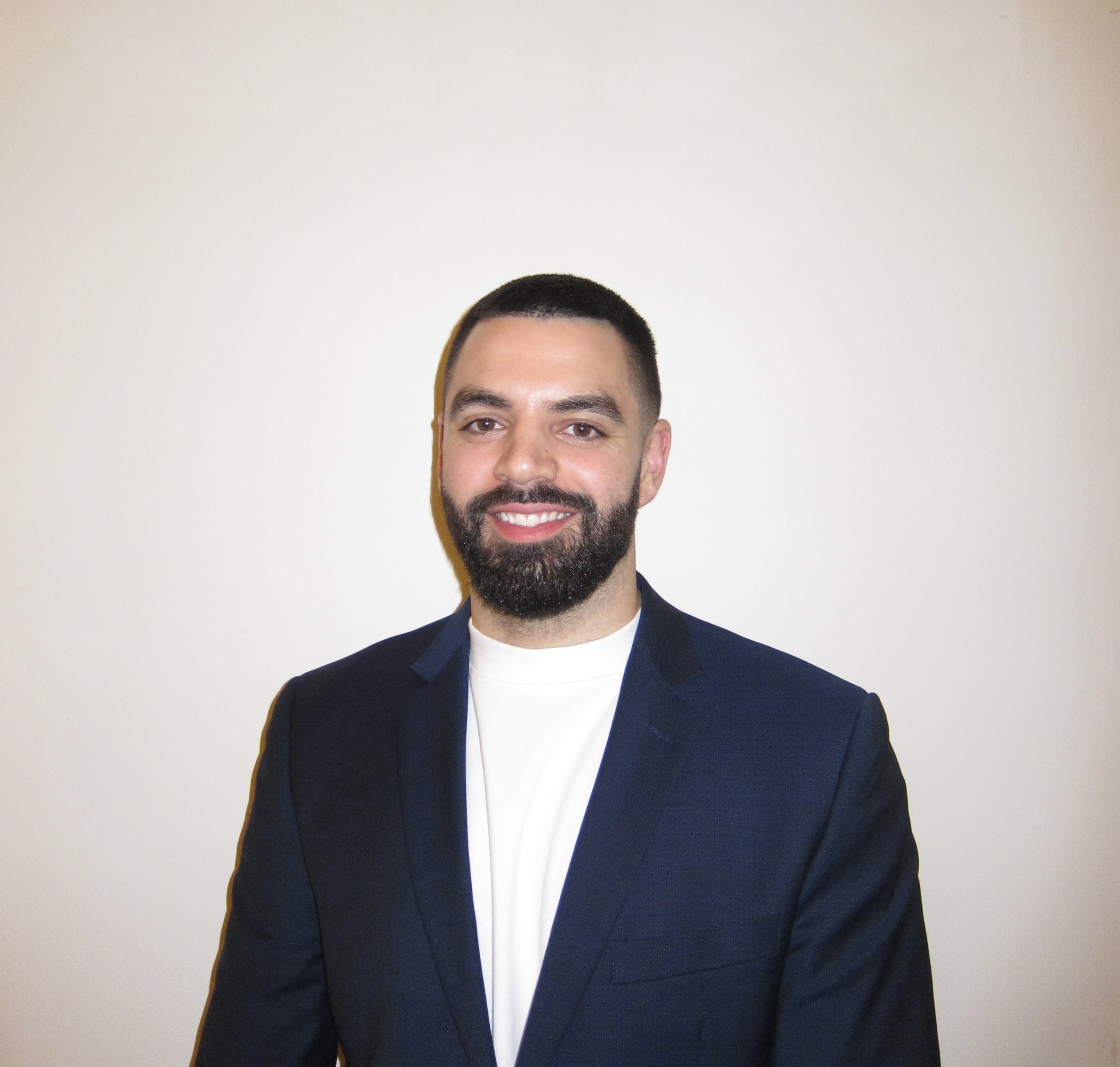 Portrait photo of Kareem in a navy suit