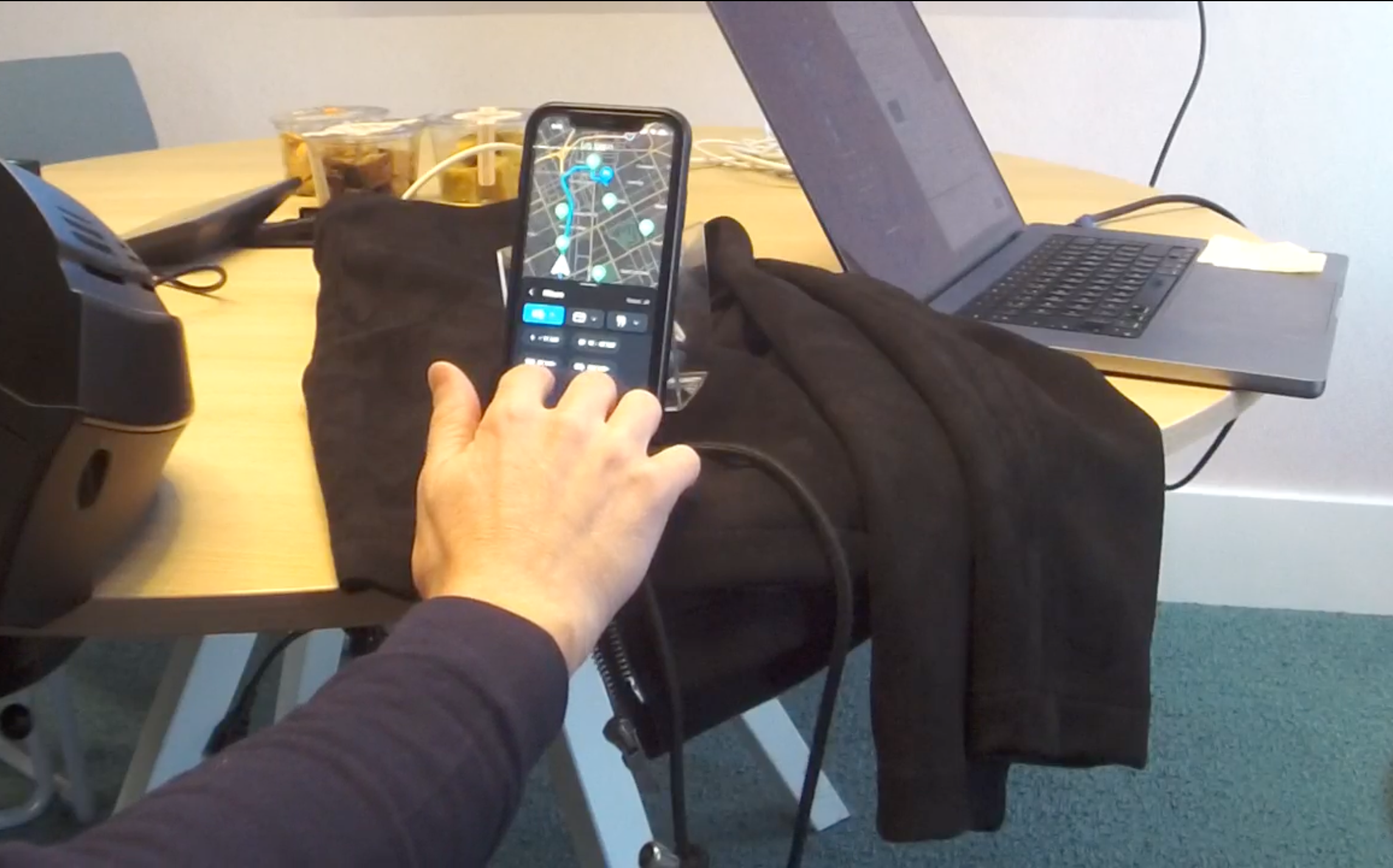 Usability test participant reaching for a mounted phone showing the charger finder filters during a simulated drive
